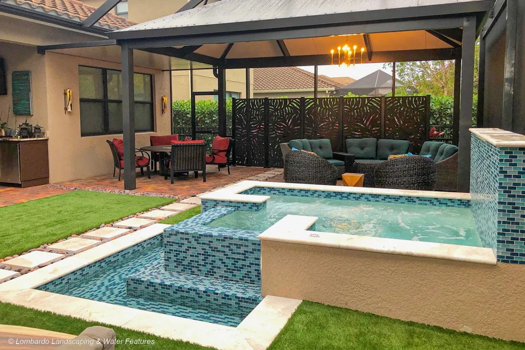 Outdoor living space with a tiled pool and spa.