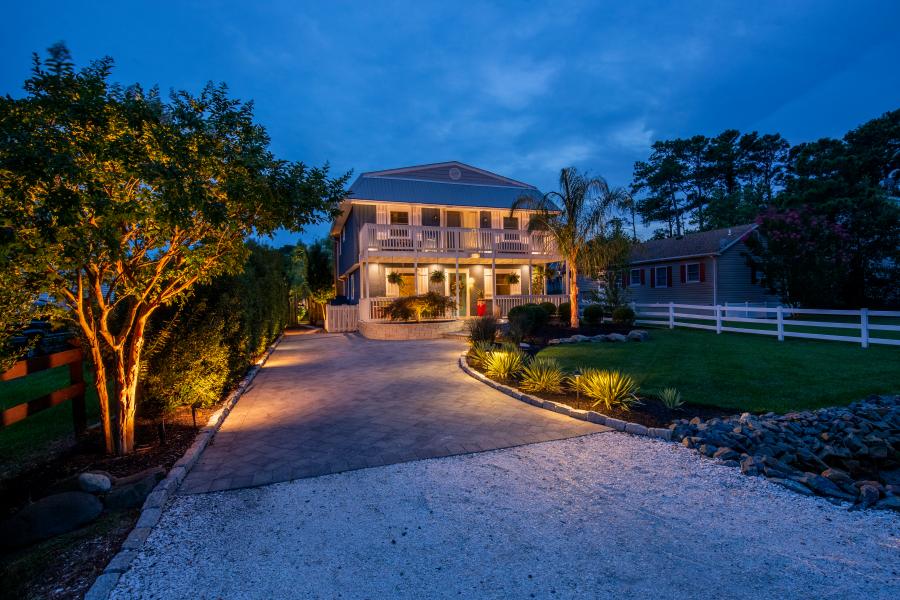 A two-story house with a paved driveway and landscaped garden.